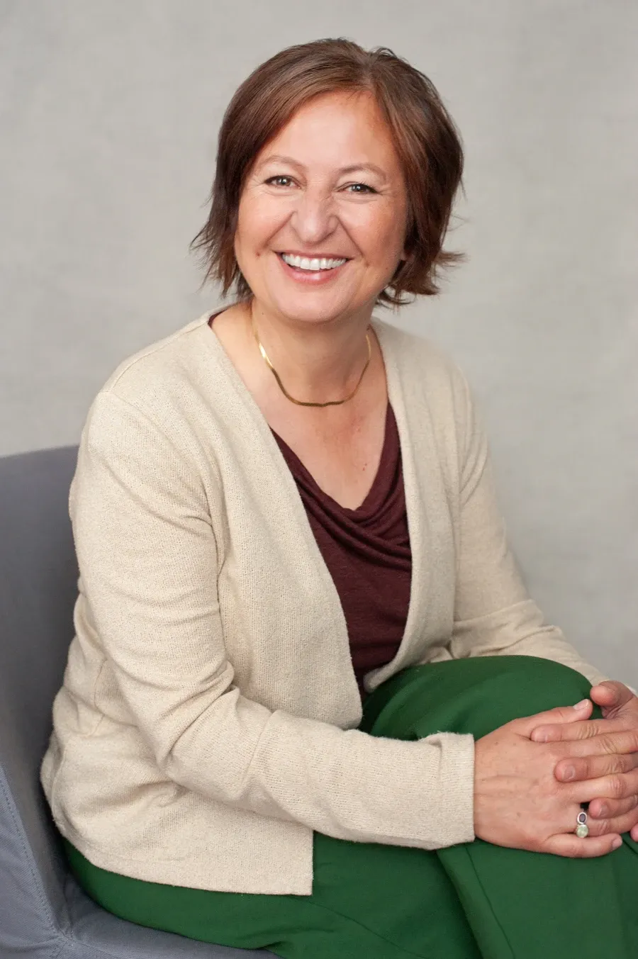 Woman sitting on a chair smiling.